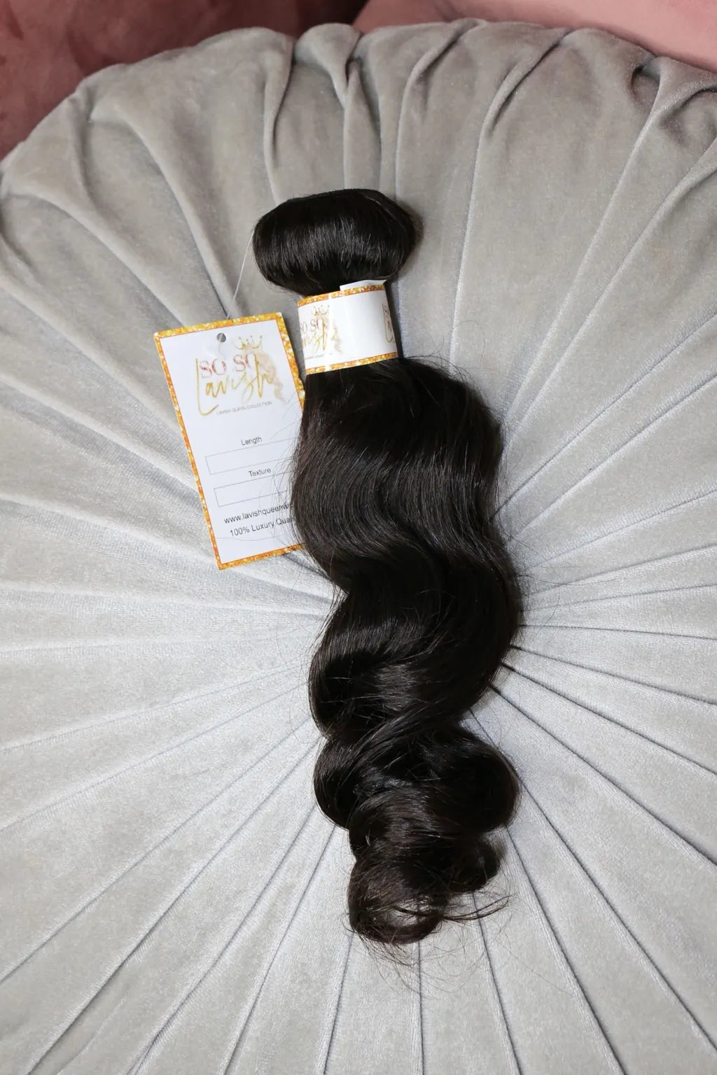Lavish Queen black body wave hair bundle on a velvet cushion